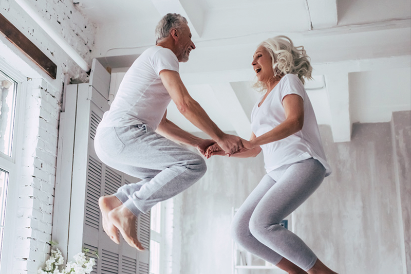 Older Couple Jumping on Bed